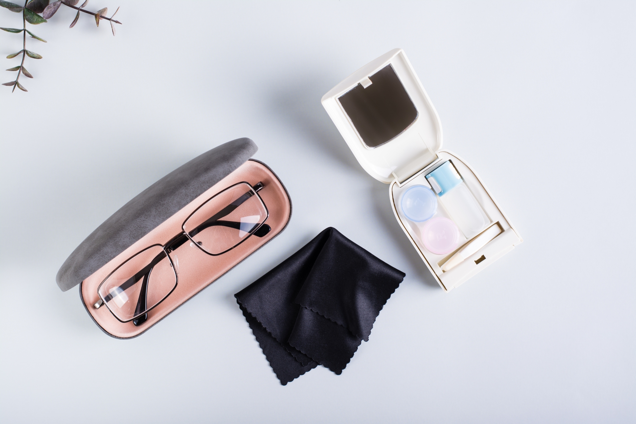 Glasses in a case, a contact lens set, and a cleaning cloth.