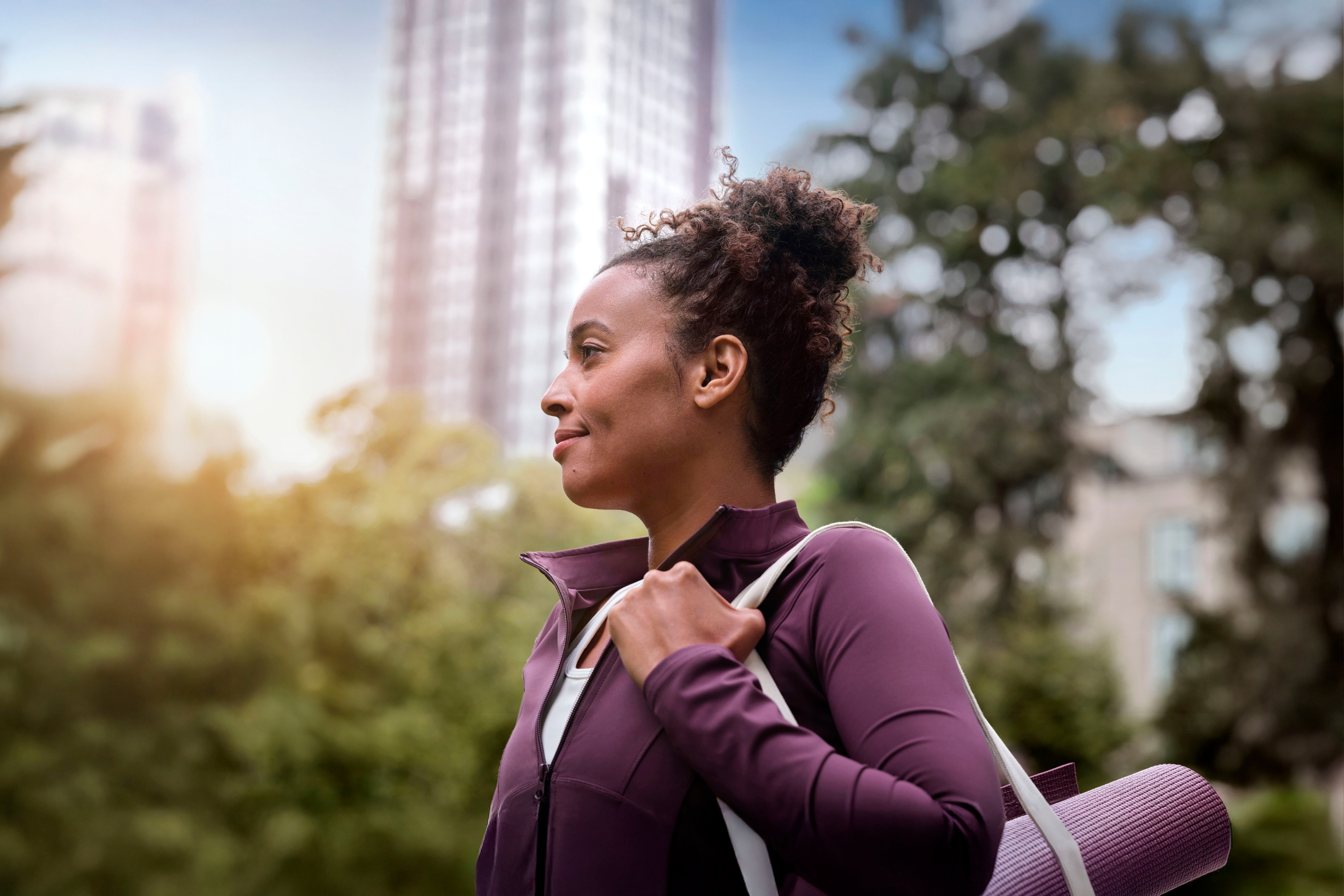 A woman walking down the street on her way to a yoga class.