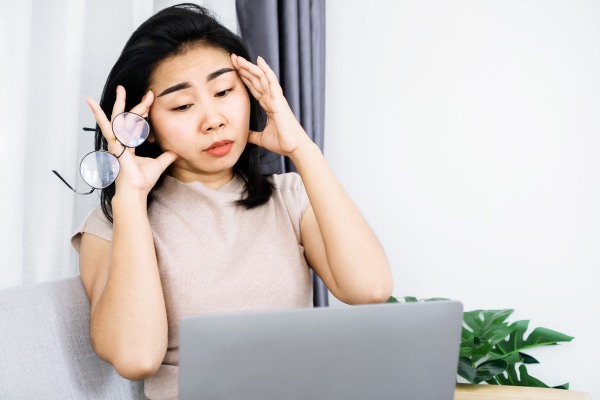 woman woman having headache and tired her eyes from overworked on computer screen hand holding eyeglasses