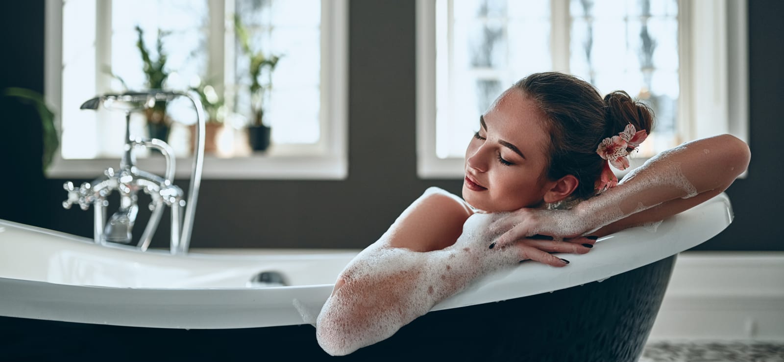 Eine Frau entspannt in einer modernen freistehenden Badewanne