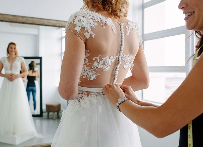 Woman dressing in wedding dress