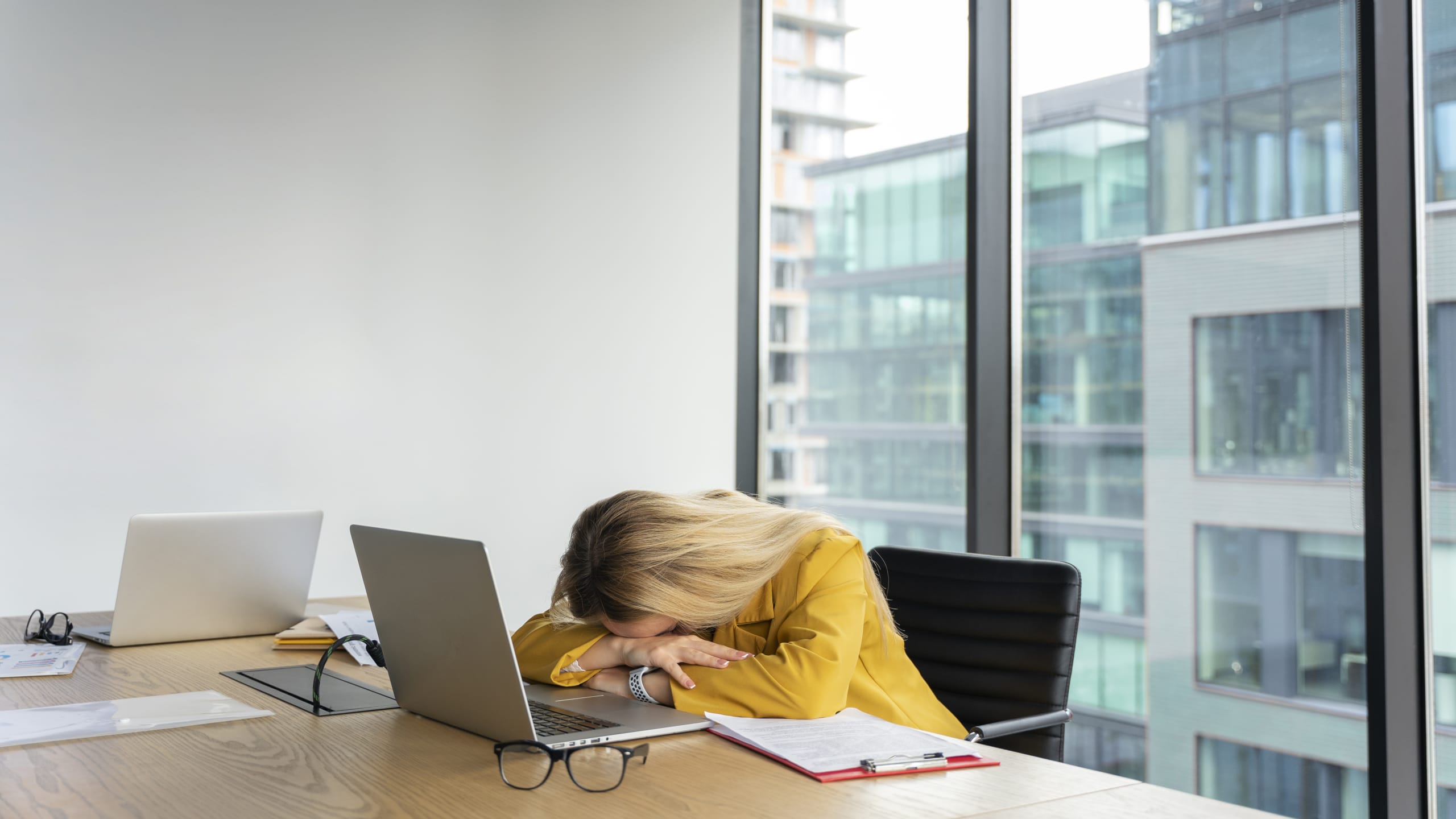 Jeune femme épuisée dormant sur son bureau illustrant le burn-out professionnel