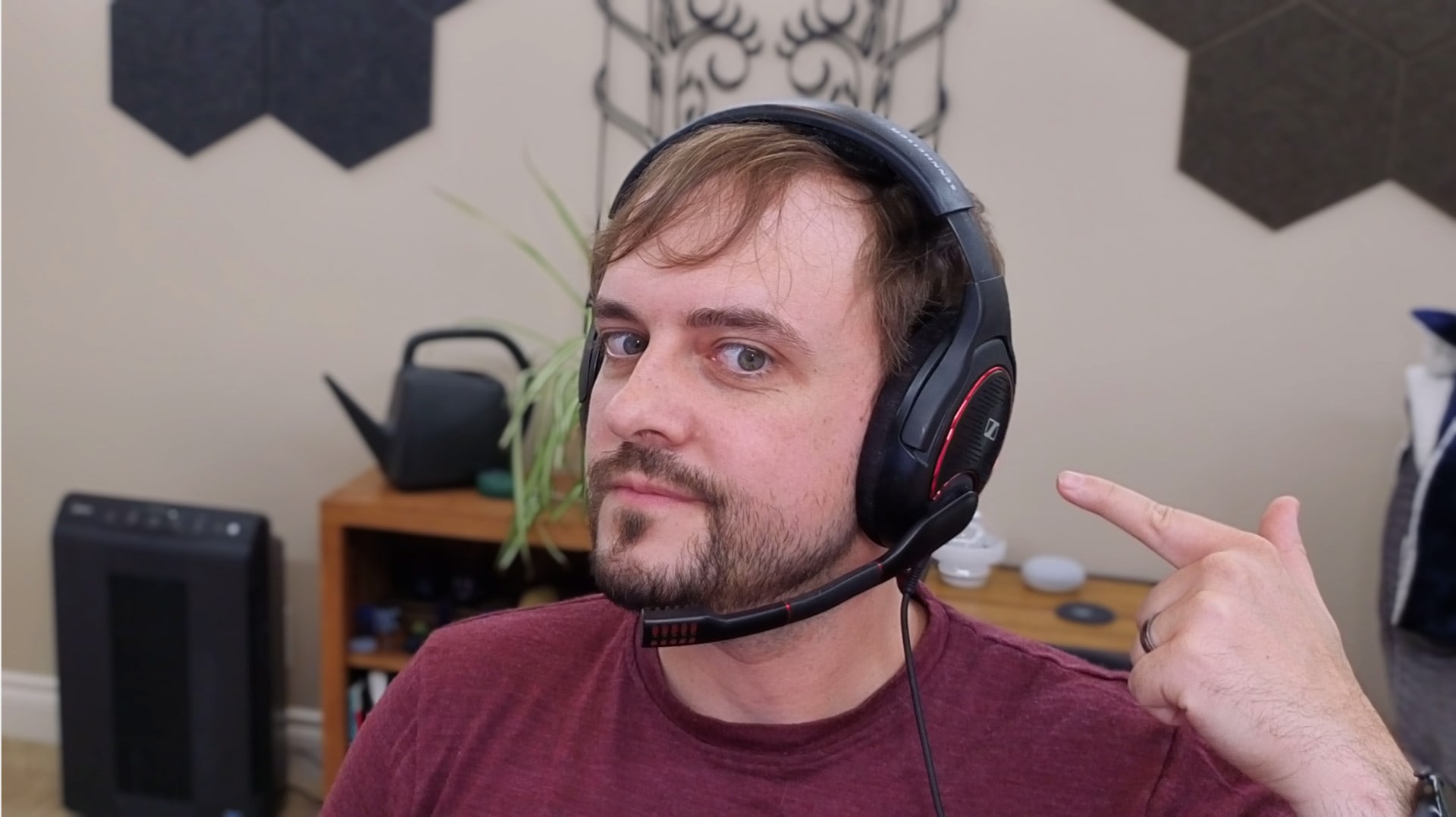 The author wearing a gaming headset and posing while pointing at the headset.