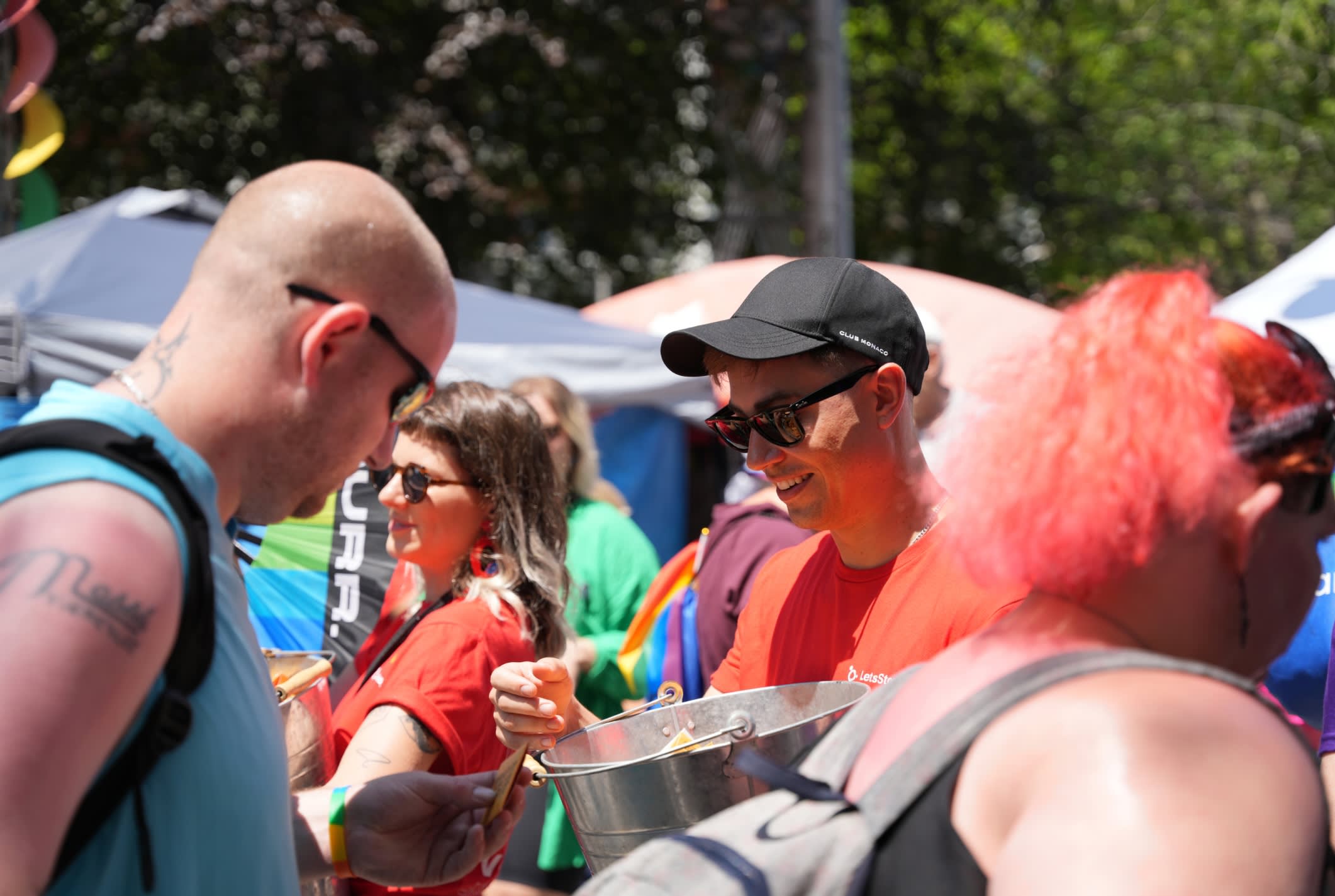 A candid image of LetsStopAIDS volunteer passing out condoms at Pride Toronto