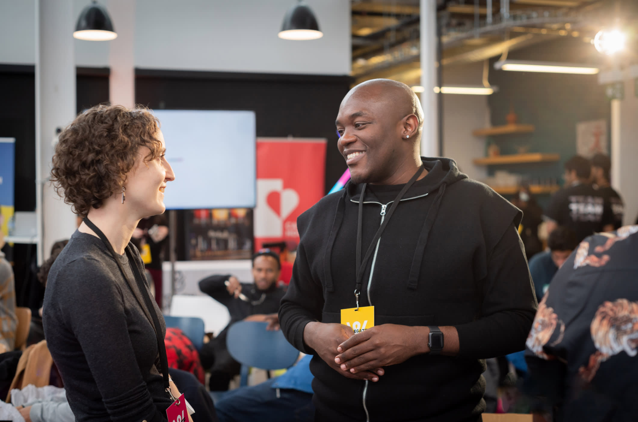 Two individuals smiling at each other and having a conversation, at NoTimeTimeToWait Event