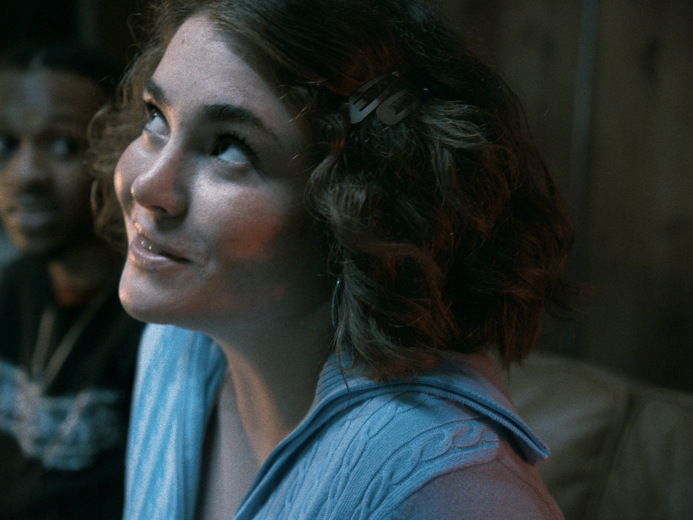 A girl looking up with a smile on her face, her expression showing happiness.