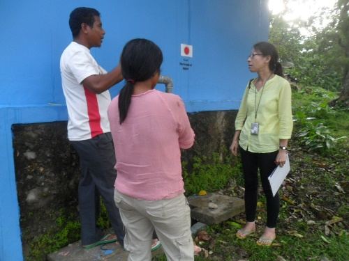 A technical partner and community member reviewing a completed WASH facility.