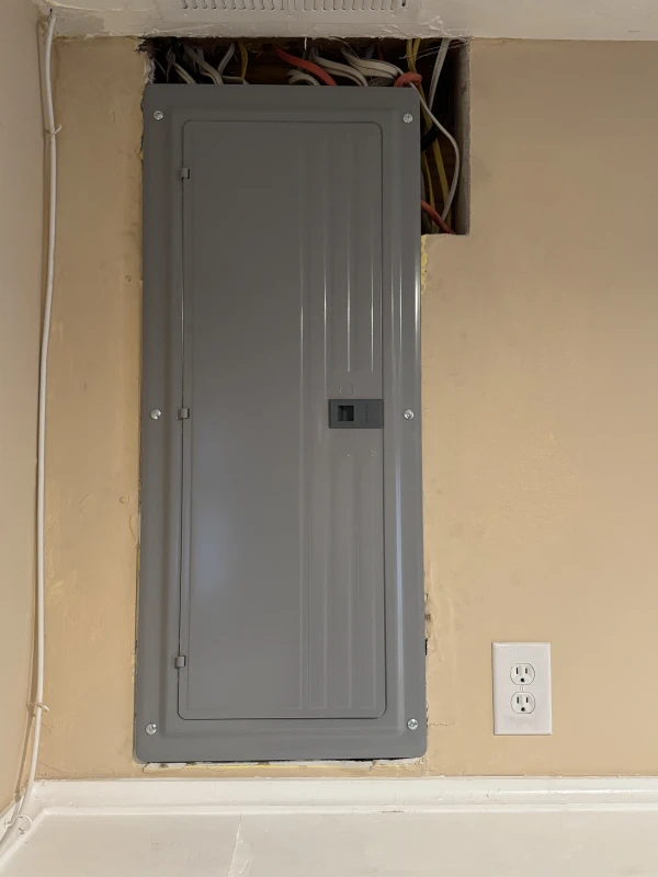 (After) New 200 amp main load center installed indoors, replacing the outdated 100 amp panel. Wiring was neatly re-terminated, and the setup allows for future expansion with proper circuit separation.