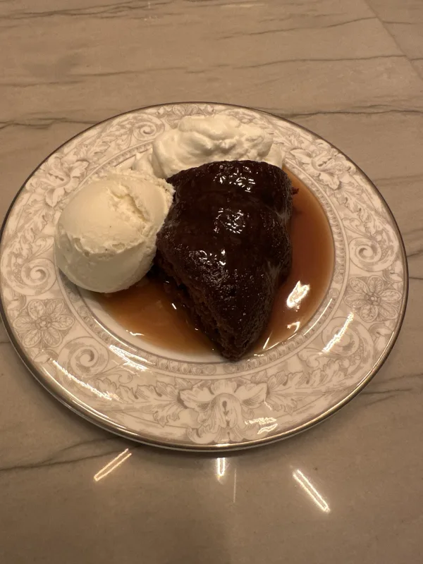 Sticky toffee pudding, brown butter vanilla ice cream, whipped cream. 