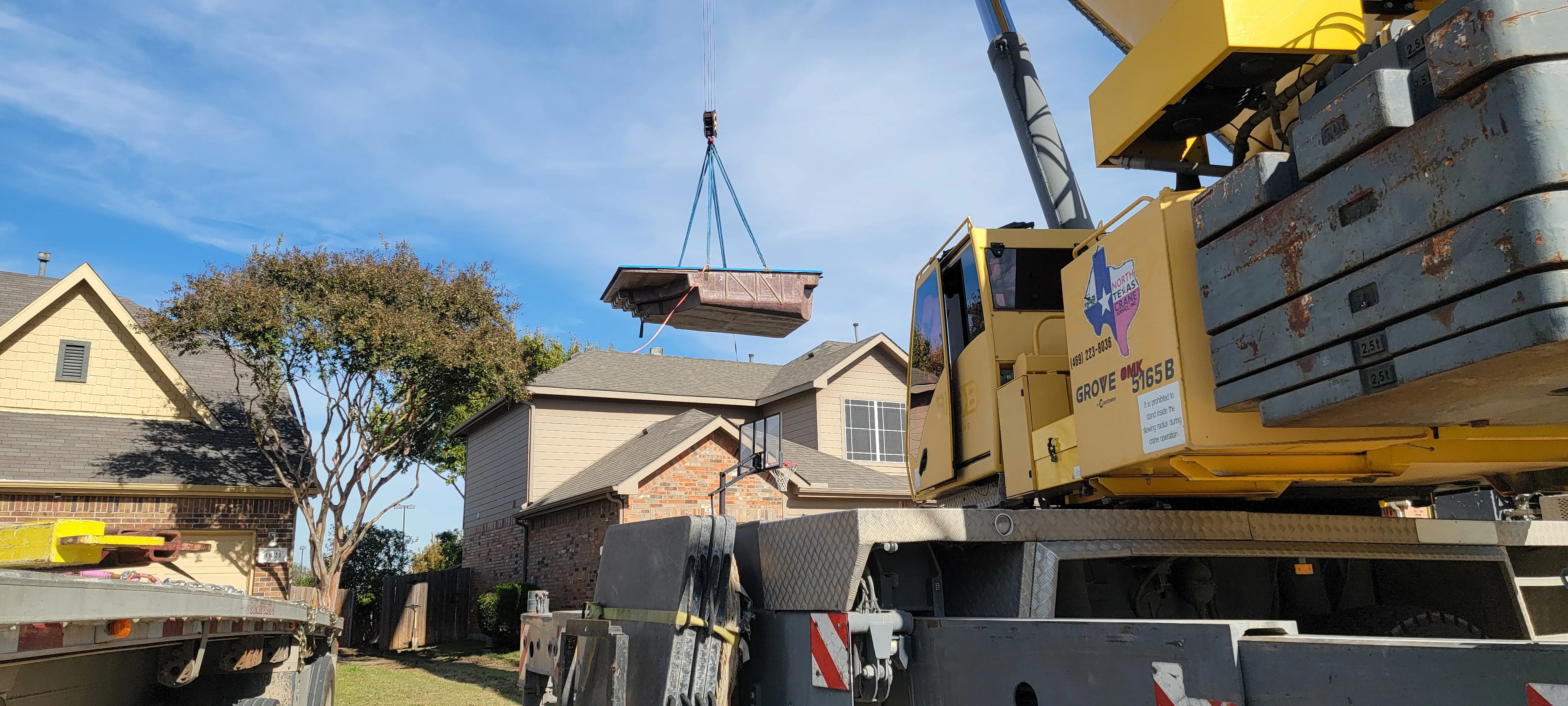 Crane lifting pool over house