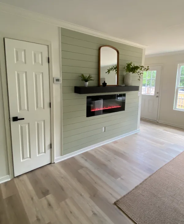 Electric fireplace mantle with shiplap backing behind it