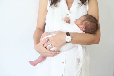 A mother holding her newborn baby boy in her arms.