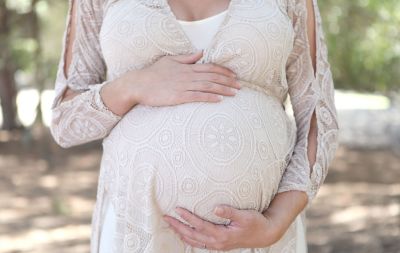 A mom to be holding her belly. 