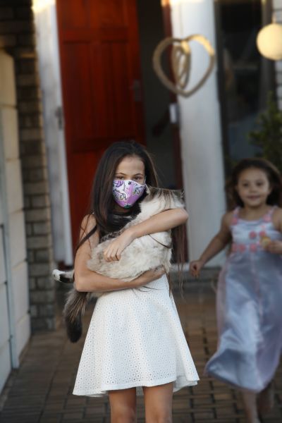 A little girl holding her cat during lockdown.