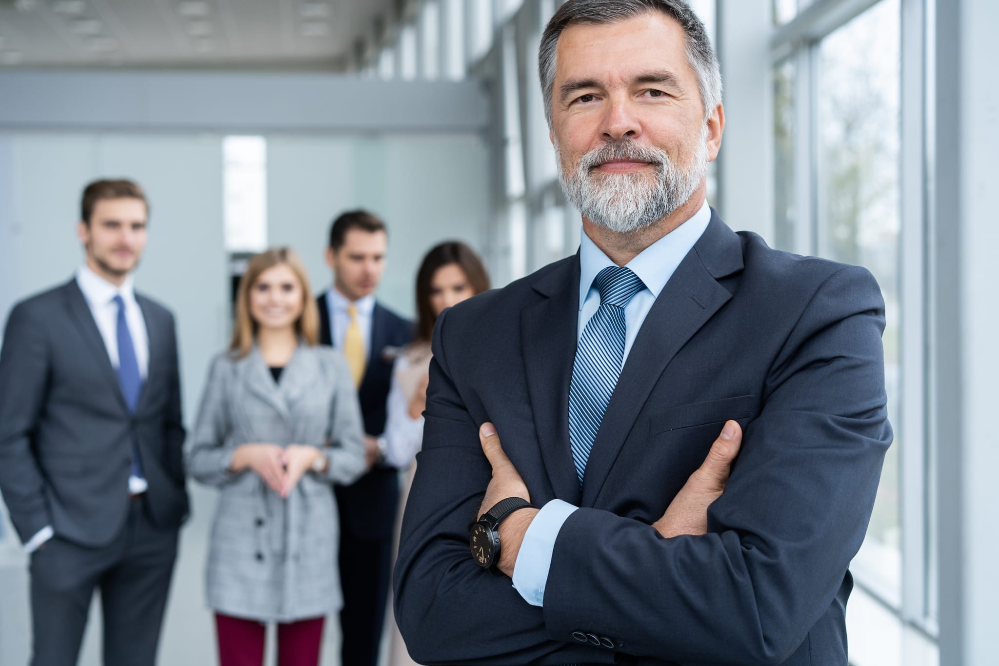 Businessteam in office, Happy Senior Businessman in His Office is standing in front of their team. Businessteam in office, Happy Senior Businessman in His Office is standing in front of their team