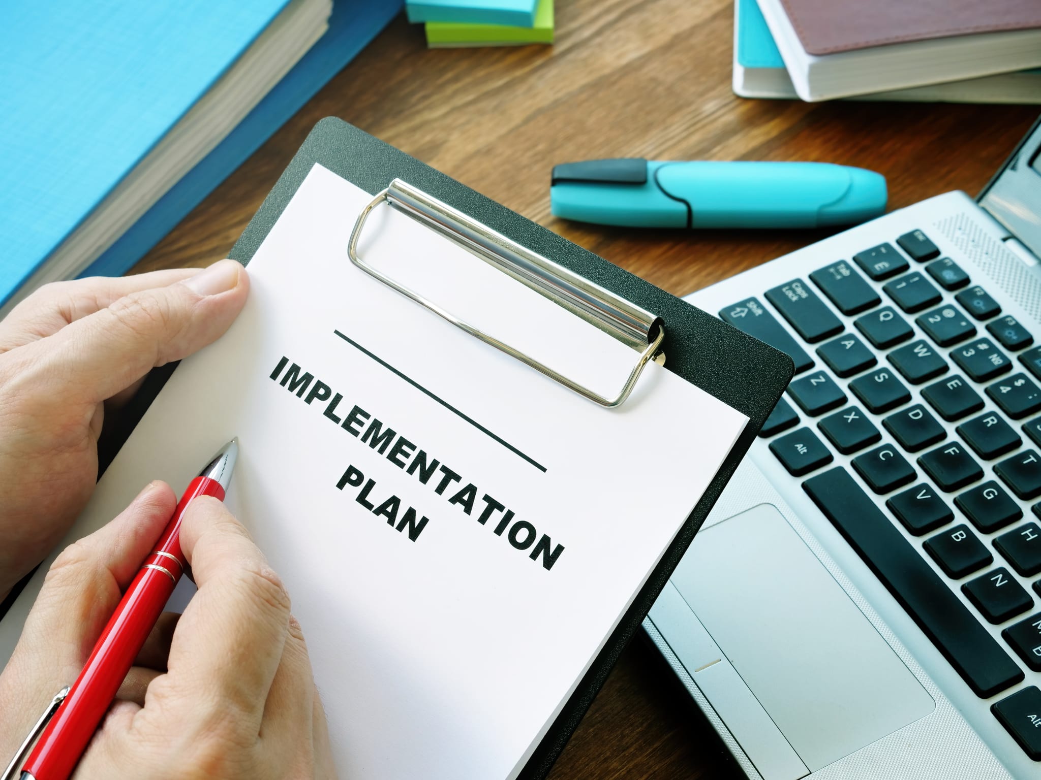 Male is writing implementation plan by the red pen. Male is writing implementation plan by the red pen.