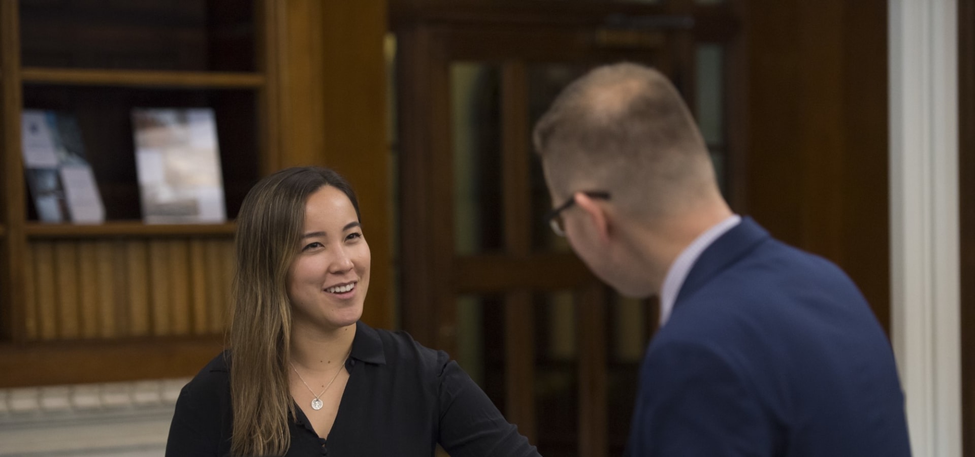 A smiling member is greeted at reception