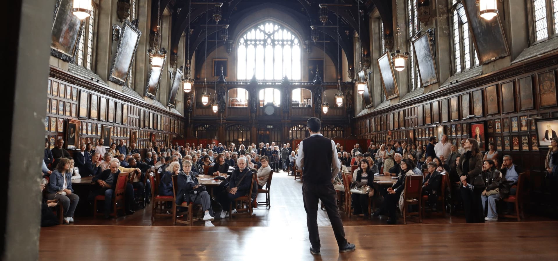 Library staff member giving a talk to a full audience in the Great Hall during Open House.