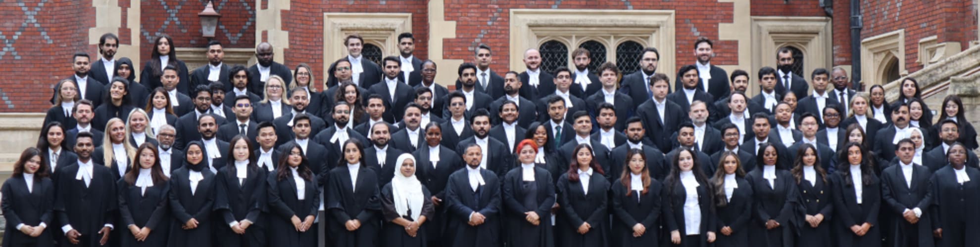 A large group of newly Called barristers pose on the steps outside Lincoln's Inn Great Hall, wearing their gowns