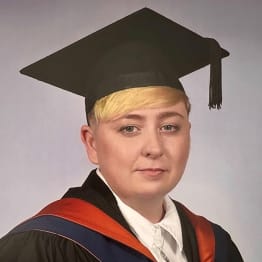 Shannon Griffiths in a mortar board and gown with red and blue satin drape.