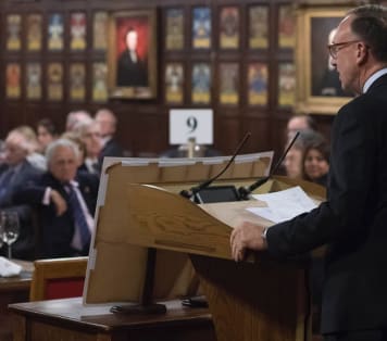 Speaker addressing guests at award ceremony in historic hall