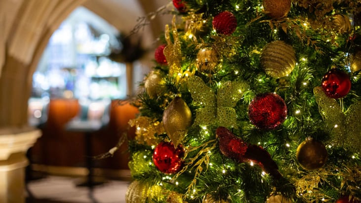 Close up of a Christmas tree with green and red baubles and white fairy lights in the MCR