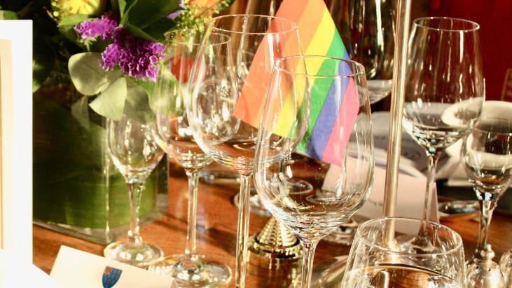 A pride flag on a dining table with the Lincoln's Inn logo.