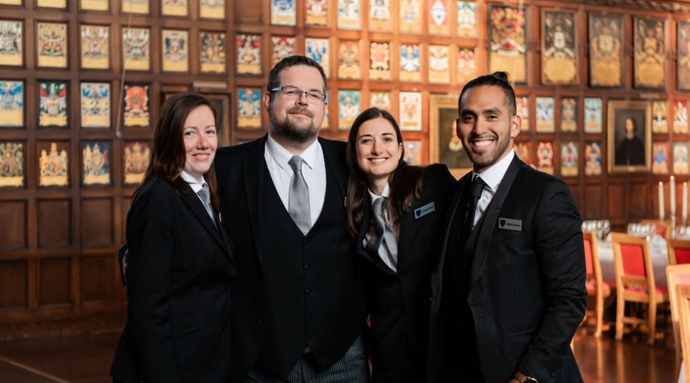 A group photo of four people smiling from the lincoln's inn front of house team