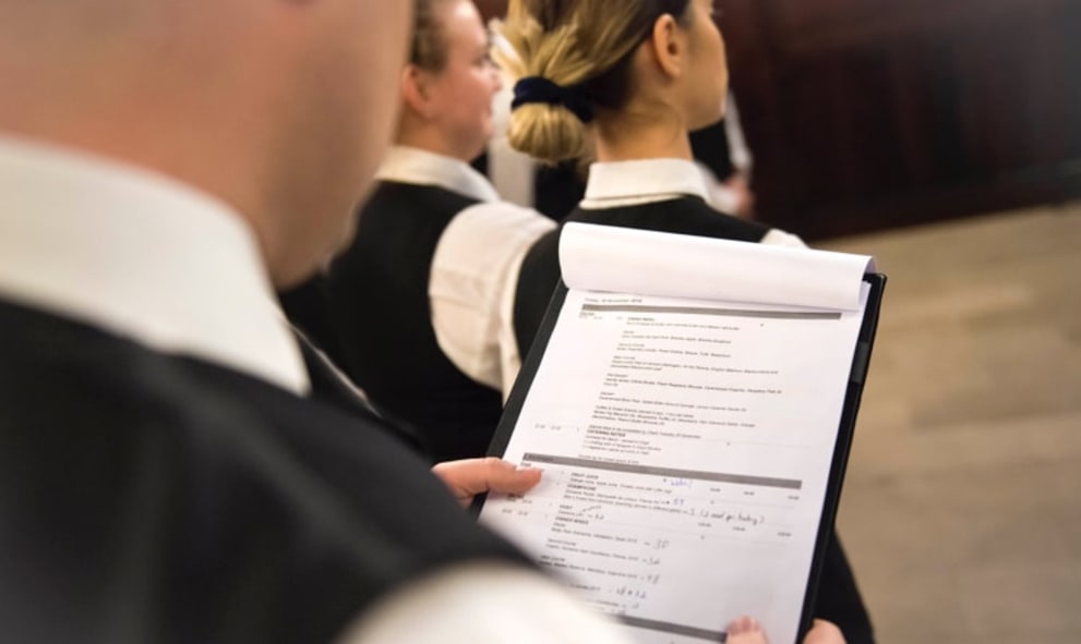 Member of staff reading brief for event in historic hall