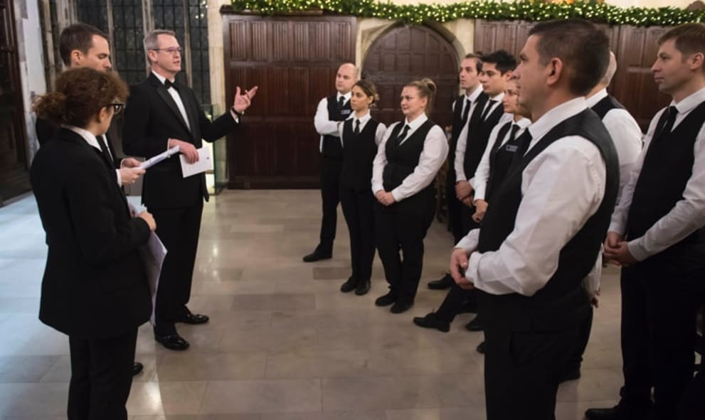 Management team briefing staff for Christmas event in historic hall