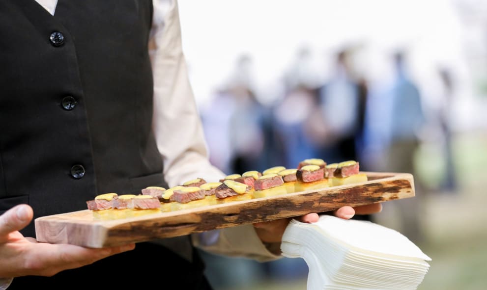 A tray of canapes being held by a server