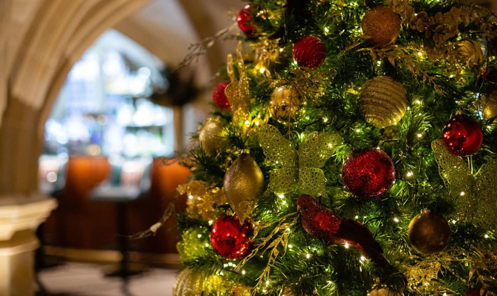 Close up of a Christmas tree with green and red baubles and white fairy lights in the MCR