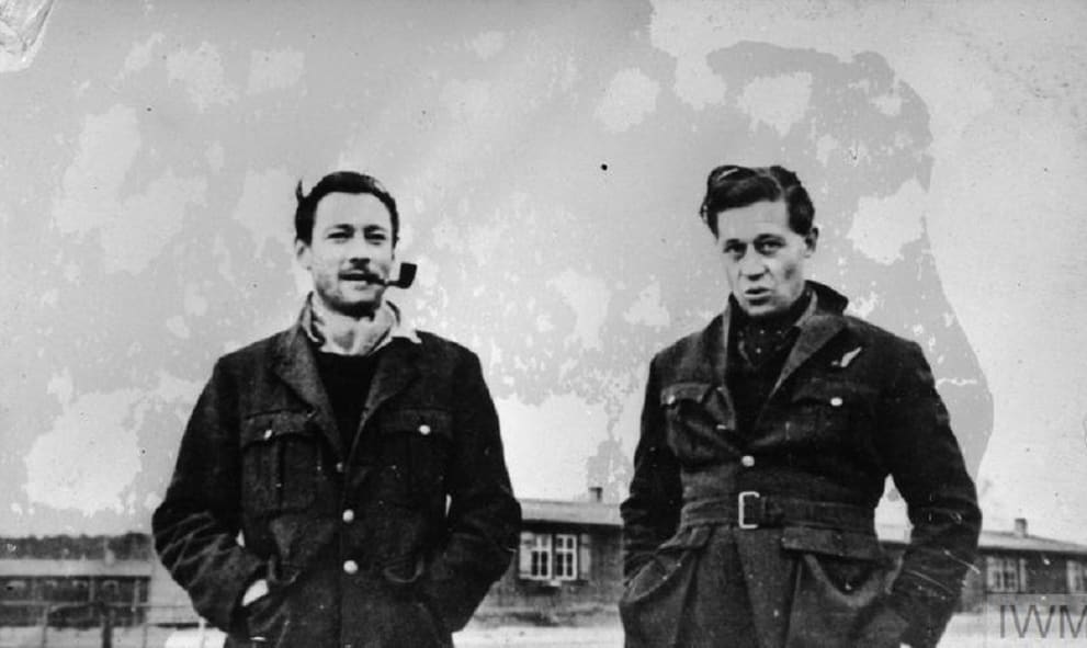 Black and white photograph of two soldiers. One has a pipe in his mouth.