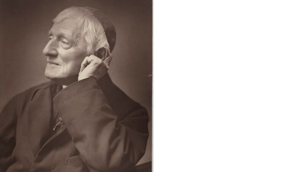 Monochrome photograph of Saint John Henry Newman. He wears a skull cap and a dark jacket.