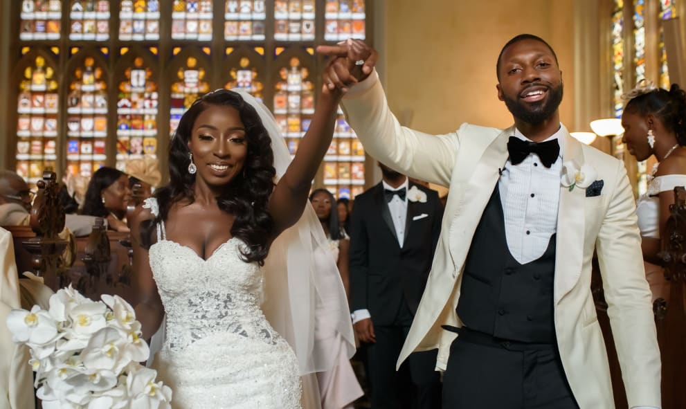 Newlywed Bride and Groom holding up their arms in celebration in the aisle of Lincoln's Inn Chapel