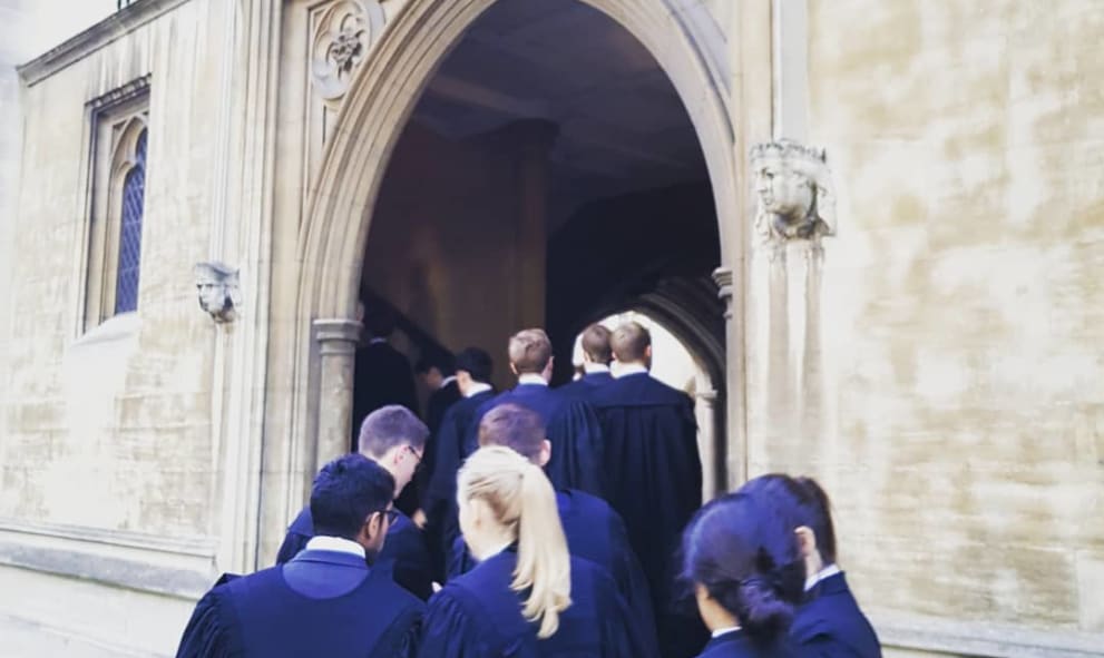 Callees dressed in gowns head into the undercroft of Lincoln's Inn.