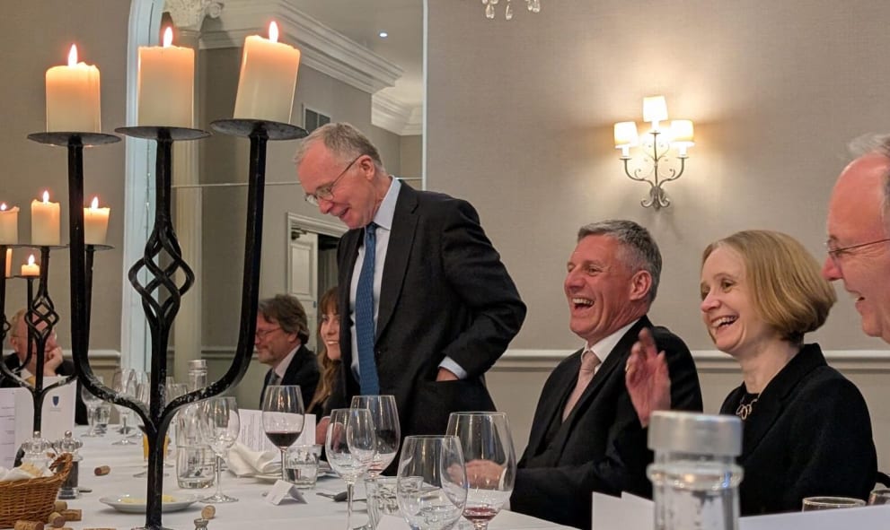 Three members laughing whilst seated for dinner