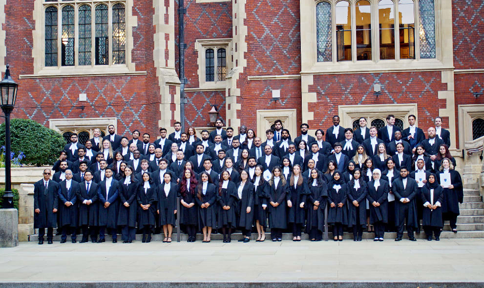 A large group of newly Called barristers pose on the steps outside Lincoln's Inn Great Hall, wearing their gowns