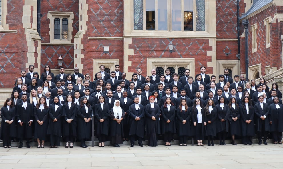 A large group of newly Called barristers pose on the steps outside Lincoln's Inn Great Hall, wearing their gowns