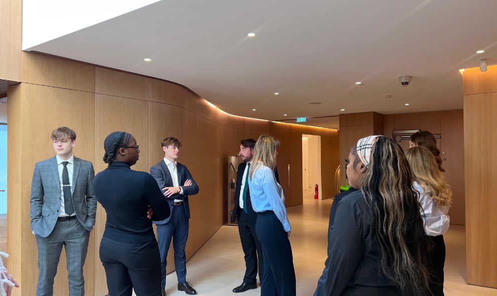 Attendees of the summer school waiting inside a hall before visiting the Old Bailey.