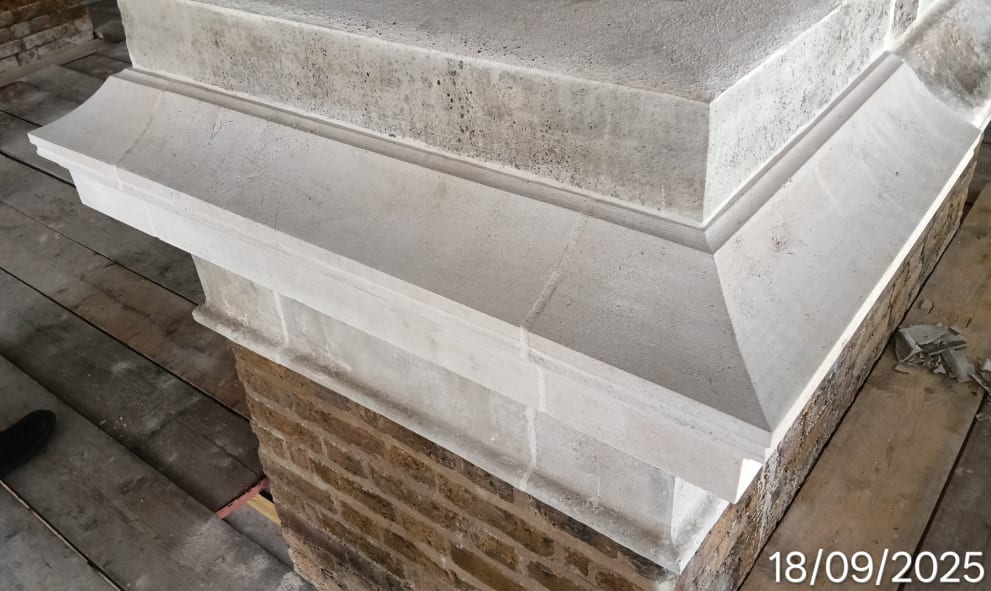 A close-up of a stone structure with detailed brickwork and sharp, clean lines, suggesting recent construction or restoration.
