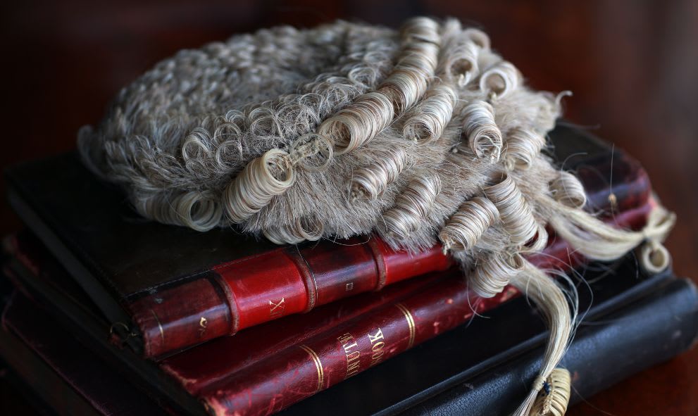 A barrister's wig resting on a stack of books.
