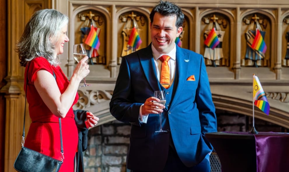 Members talking in the Council room in front of Pride flags