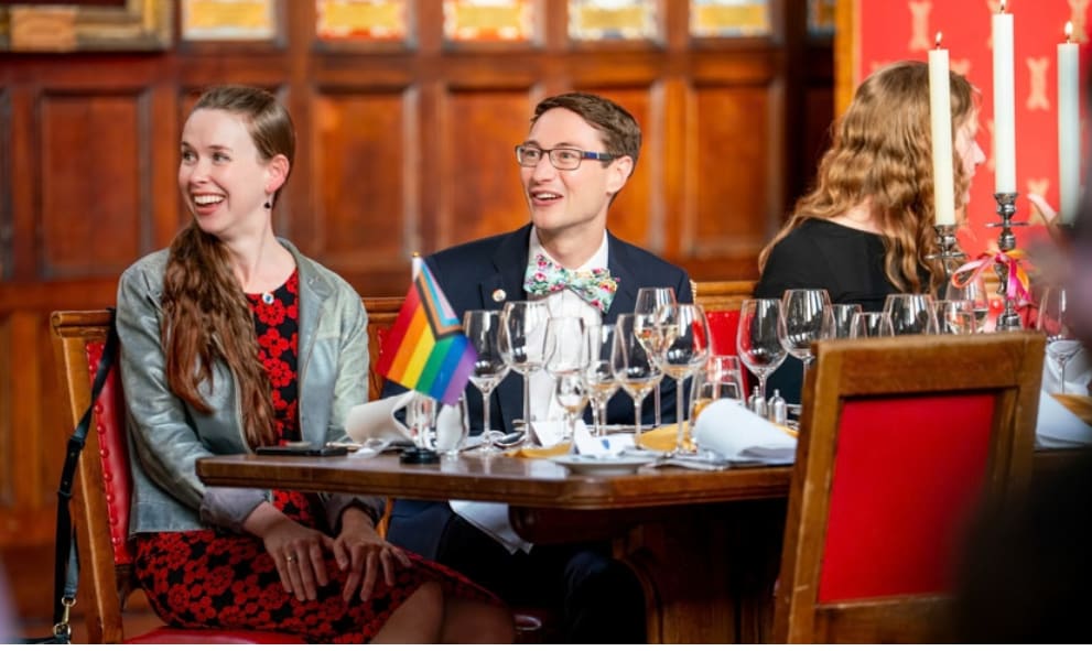 Two people sat at a table in the Great Hall, smiling