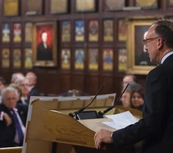 Speaker addressing guests at award ceremony in historic hall