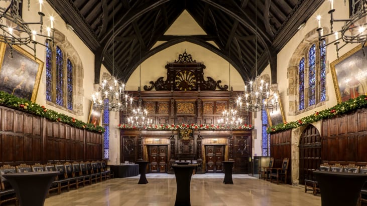 Historic hall with chandeliers decorated with Christmas decorations lining the wall