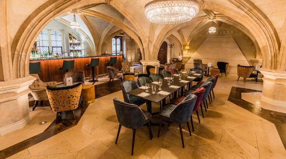 Tables set up for dining in restaurant with domed ceiling and chandelier