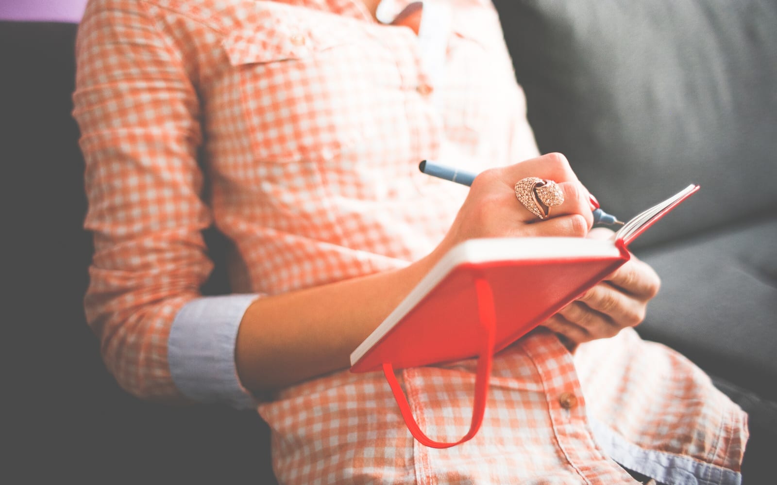 Person shown writing in a book.