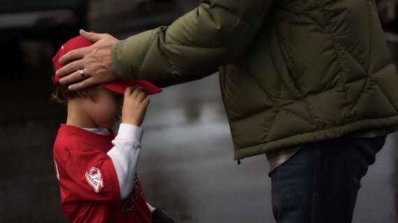 Tee Ball child with dad holding head