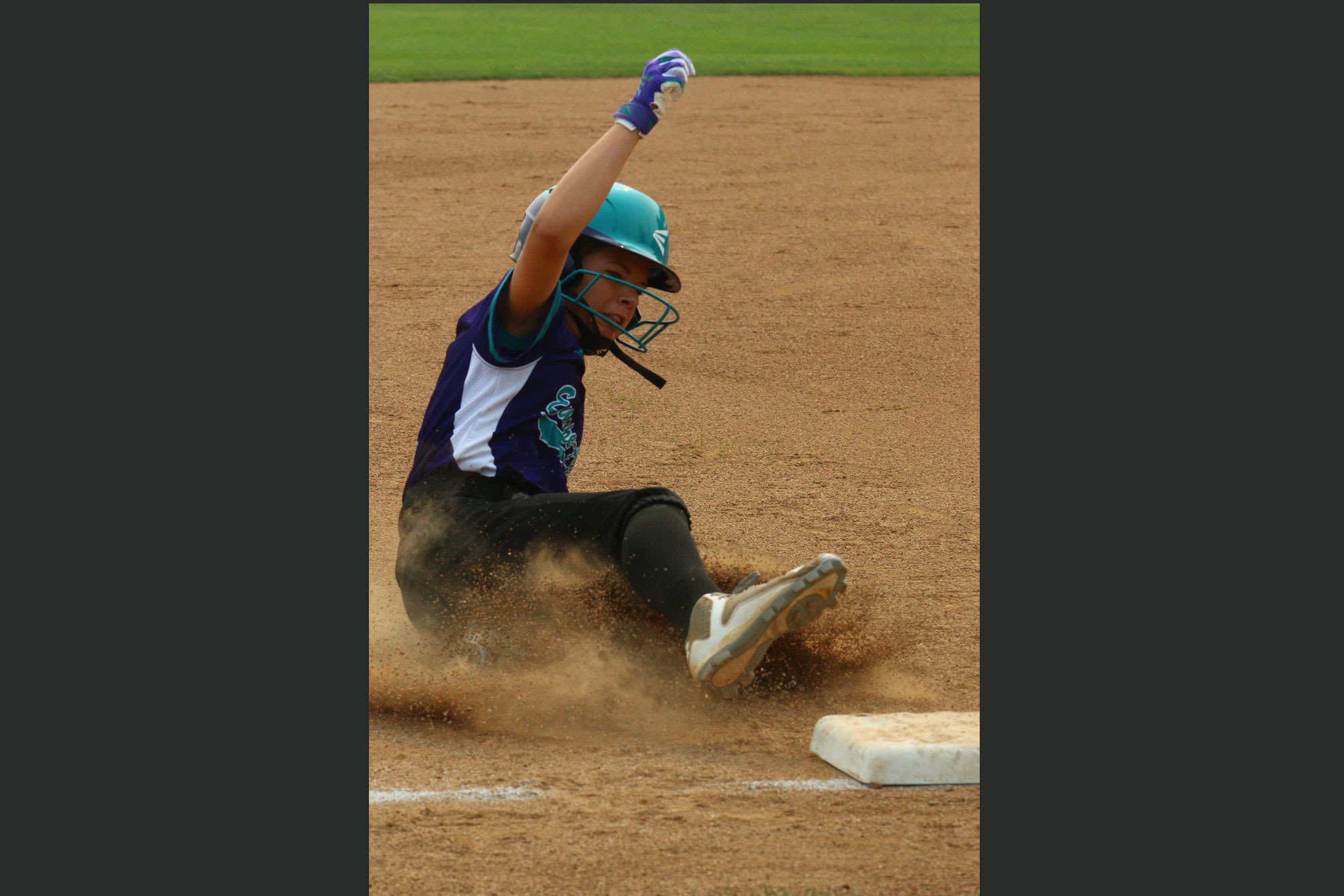 softball player sliding into base